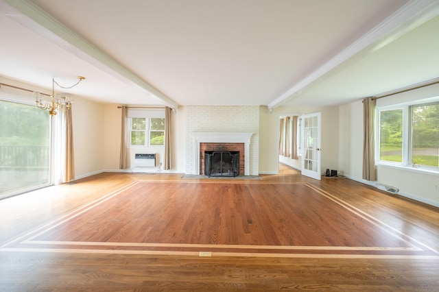 117 Long Meadow Hill Rd, Brookfield, CT 06804 - unfurnished living room featuring a brick fireplace, plenty of natural light, a wall unit AC, and wood finished floors