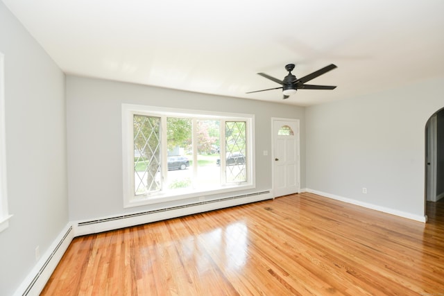 129 Tomlinson Ave, Plainville, CT 06062 - spare room with a baseboard heating unit, light wood-style floors, and arched walkways
