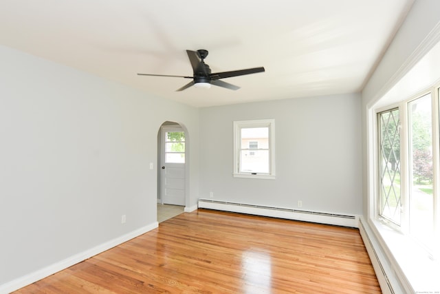 129 Tomlinson Ave, Plainville, CT 06062 - unfurnished room featuring a baseboard radiator, arched walkways, a ceiling fan, and light wood-style floors
