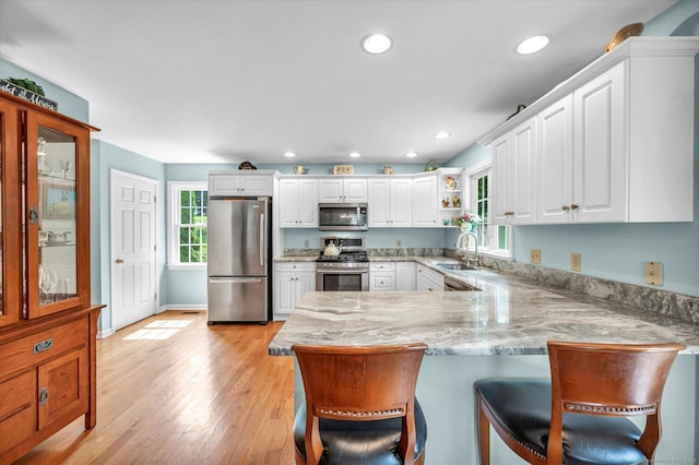 18 Overlook Ave, Middletown, CT 06457 - kitchen with stainless steel appliances, a peninsula, white cabinetry, a breakfast bar area, and recessed lighting