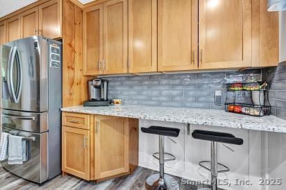 92 Seminole Ln Unit B, Stratford, CT 06614 - kitchen with freestanding refrigerator, tasteful backsplash, and light stone counters