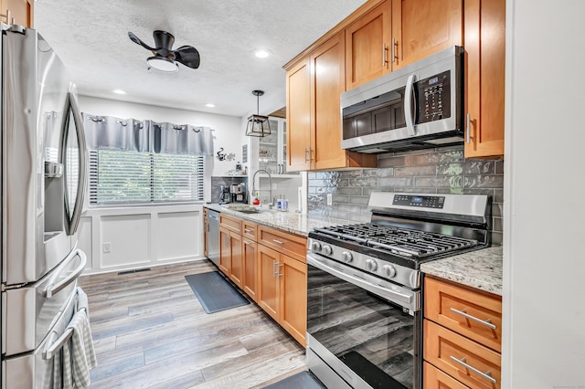 92 Seminole Ln Unit B, Stratford, CT 06614 - kitchen featuring appliances with stainless steel finishes, light wood finished floors, decorative backsplash, recessed lighting, and light stone countertops