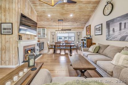 92 Seminole Ln Unit B, Stratford, CT 06614 - living area featuring wood ceiling, ceiling fan, a lit fireplace, wood finished floors, and vaulted ceiling
