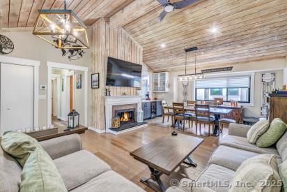 92 Seminole Ln Unit B, Stratford, CT 06614 - living room featuring wooden ceiling, a lit fireplace, lofted ceiling, a ceiling fan, and wood finished floors