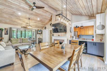 92 Seminole Ln Unit B, Stratford, CT 06614 - dining space featuring wooden ceiling, vaulted ceiling, a ceiling fan, light wood-type flooring, and a fireplace