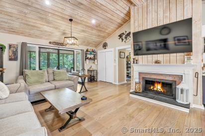 92 Seminole Ln Unit B, Stratford, CT 06614 - living room with wood ceiling, wood finished floors, a glass covered fireplace, and high vaulted ceiling