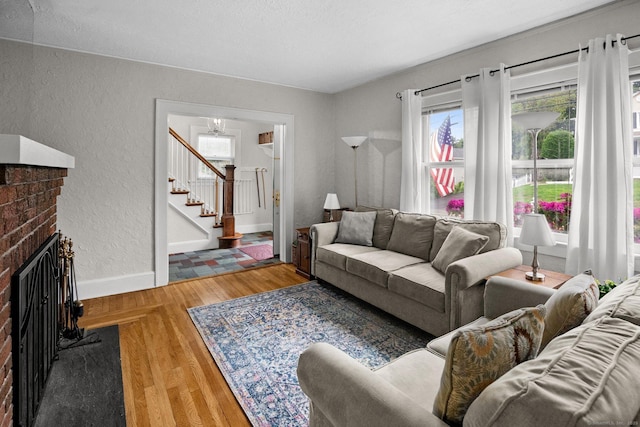 14 Maple St, Darien, CT 06820 - living room with a textured wall, stairway, a brick fireplace, and light wood finished floors