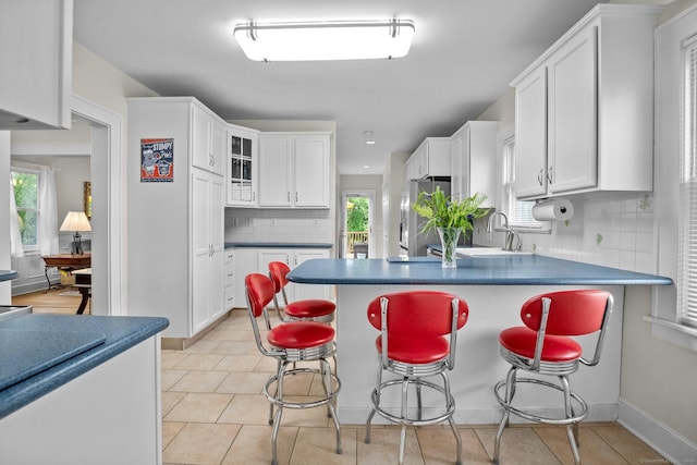14 Maple St, Darien, CT 06820 - kitchen with freestanding refrigerator, white cabinetry, a peninsula, dark countertops, and recessed lighting