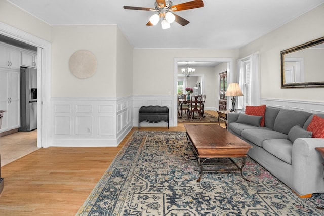 14 Maple St, Darien, CT 06820 - living area with ceiling fan, a chandelier, a wainscoted wall, and light wood finished floors