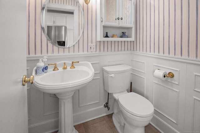 14 Maple St, Darien, CT 06820 - bathroom featuring wallpapered walls, wainscoting, tile patterned flooring, and a decorative wall