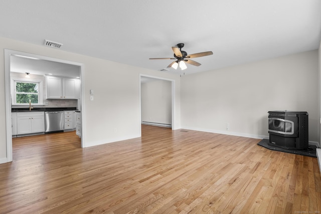 66 Pinnacle Rd, Bristol, CT 06010 - unfurnished living room with a wood stove, light wood-style floors, and a ceiling fan