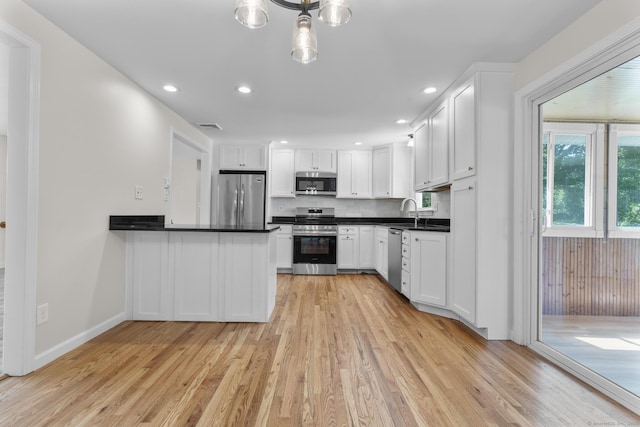 66 Pinnacle Rd, Bristol, CT 06010 - kitchen with stainless steel appliances, light wood finished floors, dark countertops, white cabinets, and recessed lighting