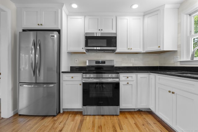 66 Pinnacle Rd, Bristol, CT 06010 - kitchen featuring appliances with stainless steel finishes, white cabinets, dark countertops, light wood-type flooring, and recessed lighting