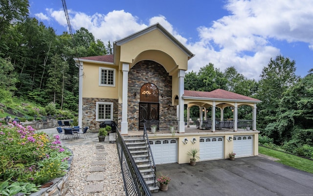 2 Barberry Ln, Farmington, CT 06032 - mediterranean / spanish-style home featuring stucco siding, an attached garage, stone siding, and asphalt driveway