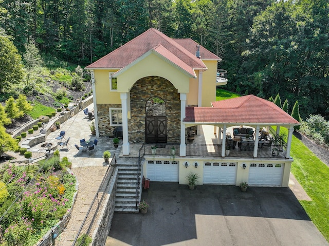 2 Barberry Ln, Farmington, CT 06032 - mediterranean / spanish-style home with a garage, asphalt driveway, stairs, stucco siding, and stone siding