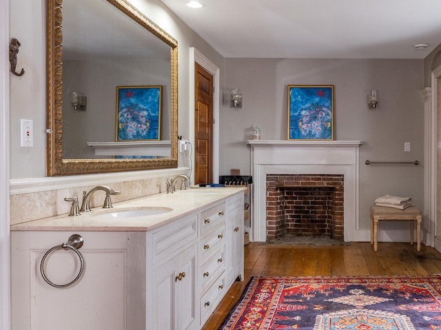 850 Noank Rd, Groton, CT 06355 - bathroom featuring wood-type flooring, a fireplace with flush hearth, and double vanity