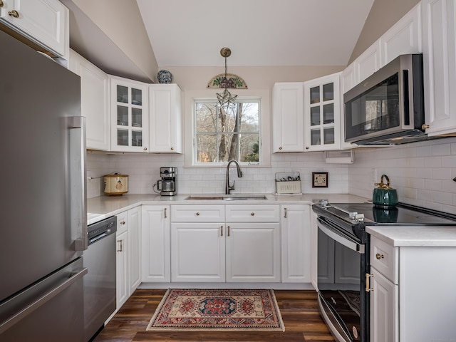 850 Noank Rd, Groton, CT 06355 - kitchen featuring appliances with stainless steel finishes, vaulted ceiling, light countertops, backsplash, and glass insert cabinets