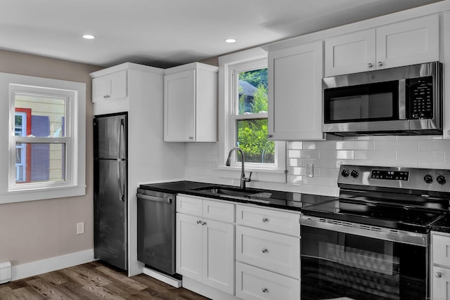 300 Central Ave, Norwich, CT 06360 - kitchen with appliances with stainless steel finishes, backsplash, dark wood-style flooring, white cabinets, and recessed lighting
