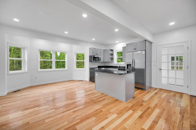 339 Main St, Wallingford, CT 06492 - kitchen with appliances with stainless steel finishes, gray cabinets, open shelves, light wood-type flooring, and a kitchen island