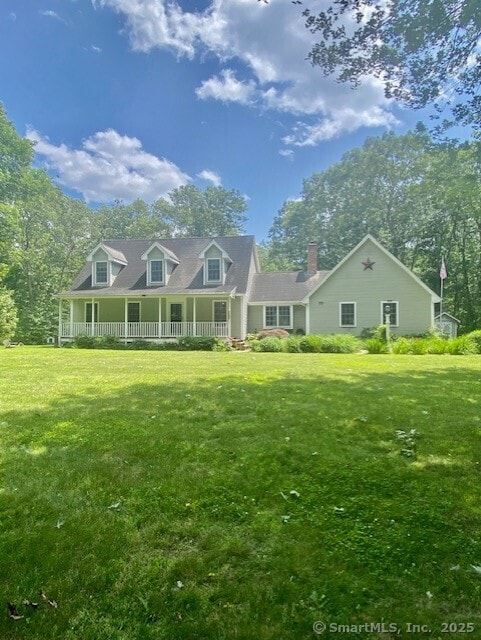 42 Woodmont Cir, East Haddam, CT 06423 - view of front facade featuring covered porch, a front yard, and a chimney