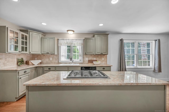 42 Woodmont Cir, East Haddam, CT 06423 - kitchen featuring stainless steel gas stovetop, a center island, gray cabinets, backsplash, and light stone counters