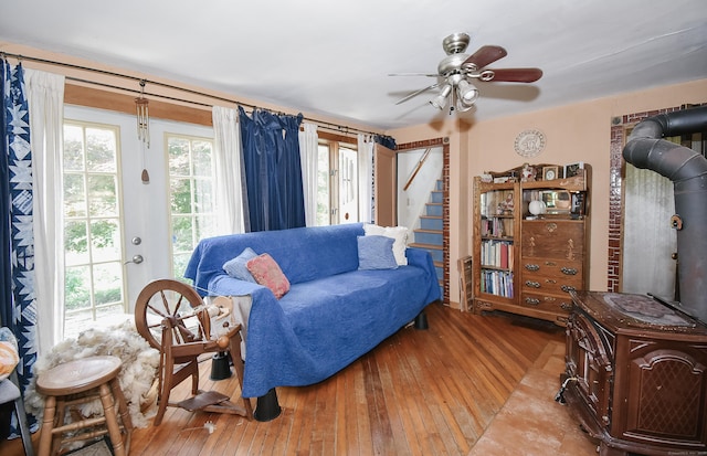 279 Pratt St, Winchester, CT 06098 - living area featuring a wood stove, wood-type flooring, ceiling fan, and stairway