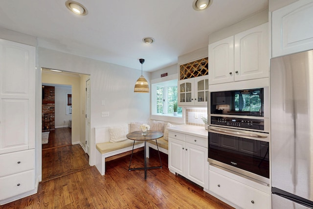 1 Whippoorwill Ln, Brookfield, CT 06804 - kitchen with stainless steel appliances, white cabinetry, glass insert cabinets, wood finished floors, and recessed lighting