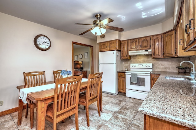 55 Mary Ellen Dr, Milford, CT 06460 - kitchen with white appliances, under cabinet range hood, brown cabinetry, and backsplash