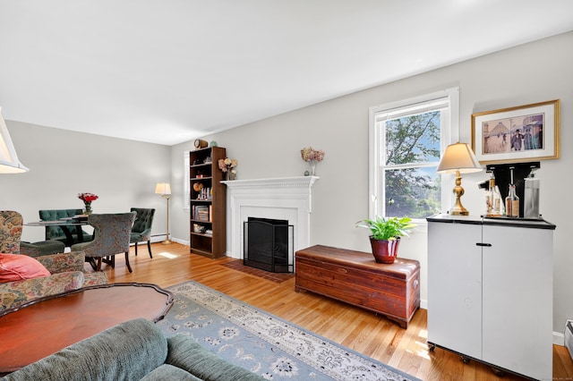 108 Pilgrim Dr, Windsor, CT 06095 - living area featuring wood finished floors, a fireplace with flush hearth, and a baseboard radiator