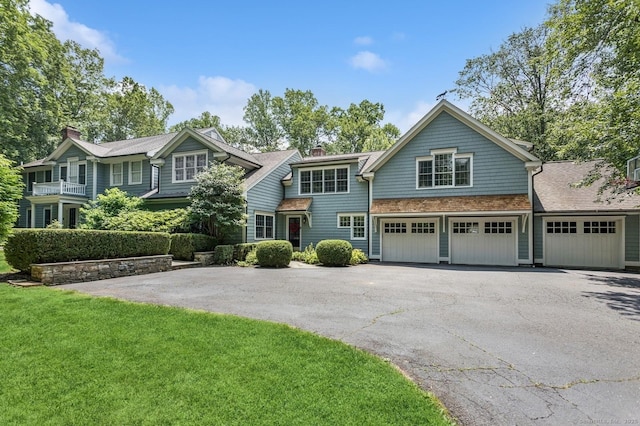 47 Tubbs Spring Dr, Weston, CT 06883 - view of front of home featuring driveway, a chimney, an attached garage, and a front yard