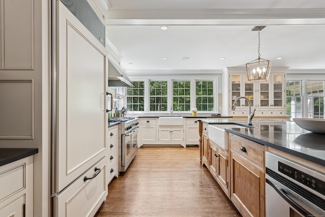 47 Tubbs Spring Dr, Weston, CT 06883 - kitchen with premium appliances, dark countertops, light wood-style floors, tasteful backsplash, and crown molding