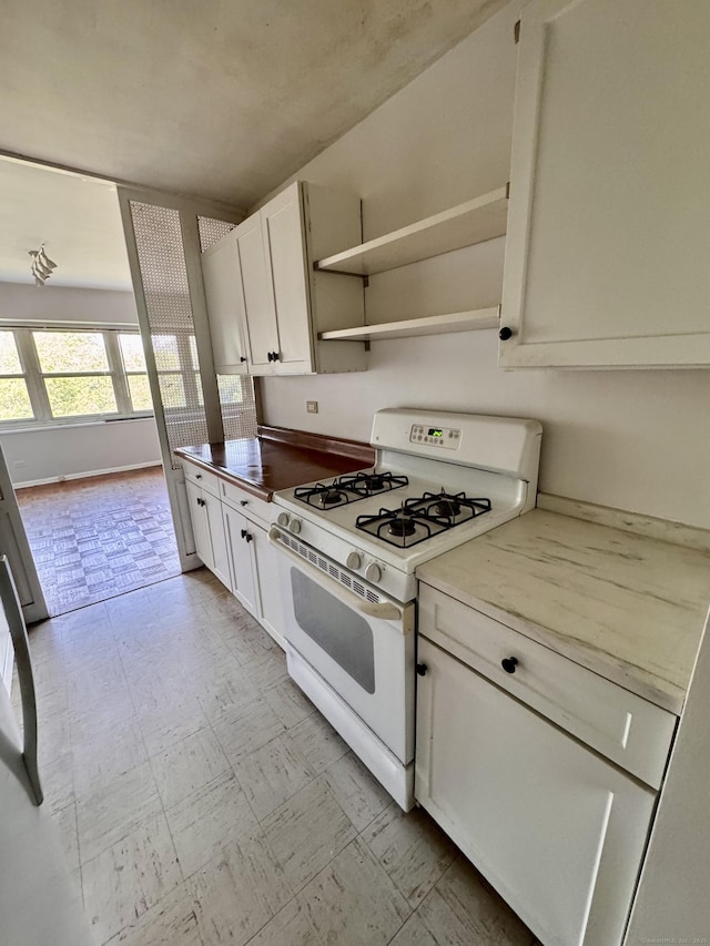 31 Woodland St Unit 7F, Hartford, CT 06103 - kitchen featuring white range with gas stovetop, white cabinetry, light floors, open shelves, and light countertops