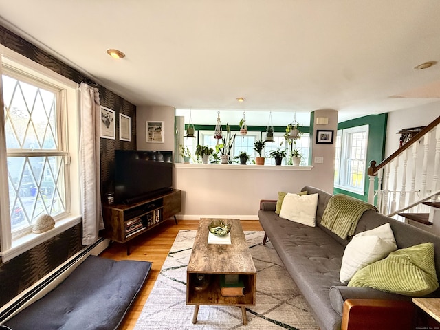 28 Grand St, New London, CT 06320 - living area featuring wood finished floors, stairs, and a baseboard radiator