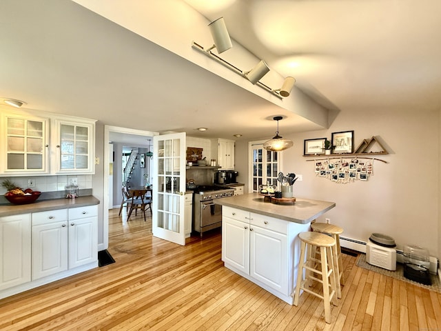 28 Grand St, New London, CT 06320 - kitchen with light wood finished floors, white cabinetry, and a kitchen breakfast bar
