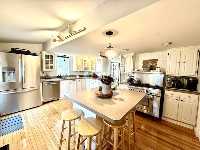 28 Grand St, New London, CT 06320 - kitchen with appliances with stainless steel finishes, white cabinets, hardwood / wood-style floors, and glass insert cabinets