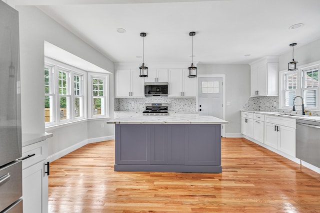 108 Adams St, New Britain, CT 06052 - kitchen with stainless steel appliances, light wood-type flooring, decorative backsplash, white cabinets, and recessed lighting