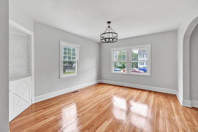 108 Adams St, New Britain, CT 06052 - unfurnished room featuring healthy amount of natural light, a chandelier, arched walkways, and wood finished floors
