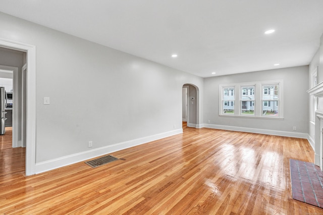 108 Adams St, New Britain, CT 06052 - unfurnished living room with arched walkways, light wood-style flooring, recessed lighting, and a fireplace