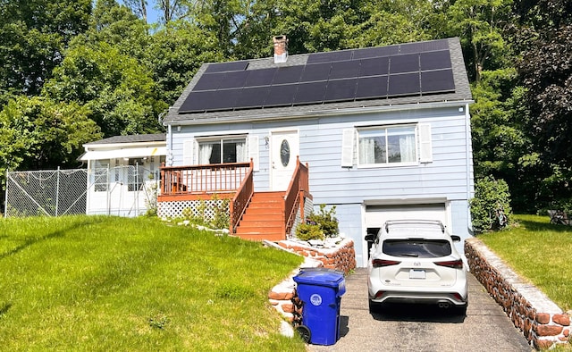 30 Roulin St, Torrington, CT 06790 - view of front facade featuring a chimney, roof mounted solar panels, a garage, and asphalt driveway