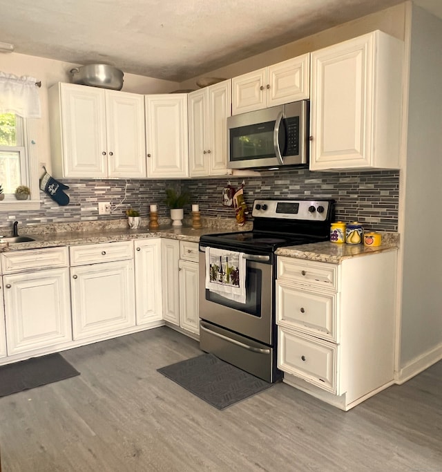 30 Roulin St, Torrington, CT 06790 - kitchen with appliances with stainless steel finishes, wood finished floors, and decorative backsplash