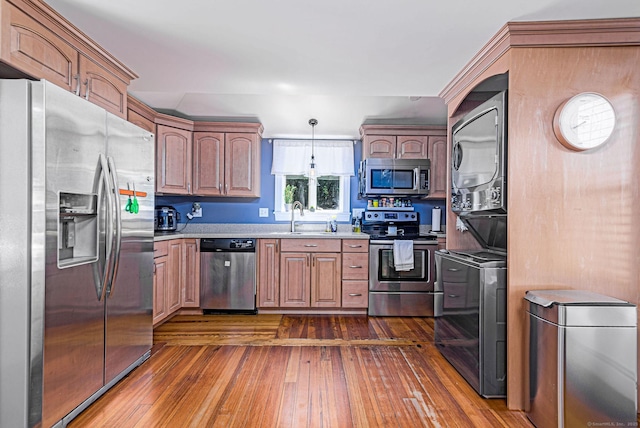 8 Johnson St, Stonington, CT 06379 - kitchen featuring stainless steel appliances, stacked washer / dryer, dark wood-style flooring, light countertops, and decorative light fixtures