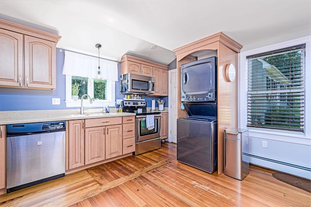 8 Johnson St, Stonington, CT 06379 - kitchen with appliances with stainless steel finishes, stacked washer / drying machine, light brown cabinetry, light countertops, and light wood-type flooring