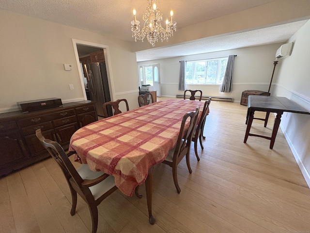 109 Middle Rd, Enfield, CT 06082 - dining room featuring a textured ceiling, a wall mounted AC, a chandelier, light wood-type flooring, and a baseboard heating unit