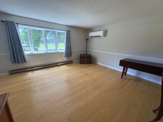 109 Middle Rd, Enfield, CT 06082 - spare room with baseboard heating, a wall mounted AC, hardwood / wood-style flooring, and a textured ceiling