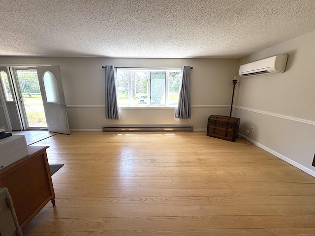 109 Middle Rd, Enfield, CT 06082 - unfurnished living room featuring an AC wall unit, a baseboard radiator, a textured ceiling, and light wood-style flooring