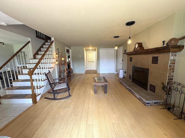 109 Middle Rd, Enfield, CT 06082 - unfurnished living room with wood-type flooring, stairs, and a tiled fireplace