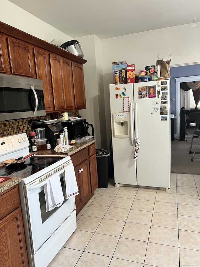 70 Burnham St, Hartford, CT 06112 - kitchen with white appliances, light tile patterned floors, backsplash, and brown cabinetry