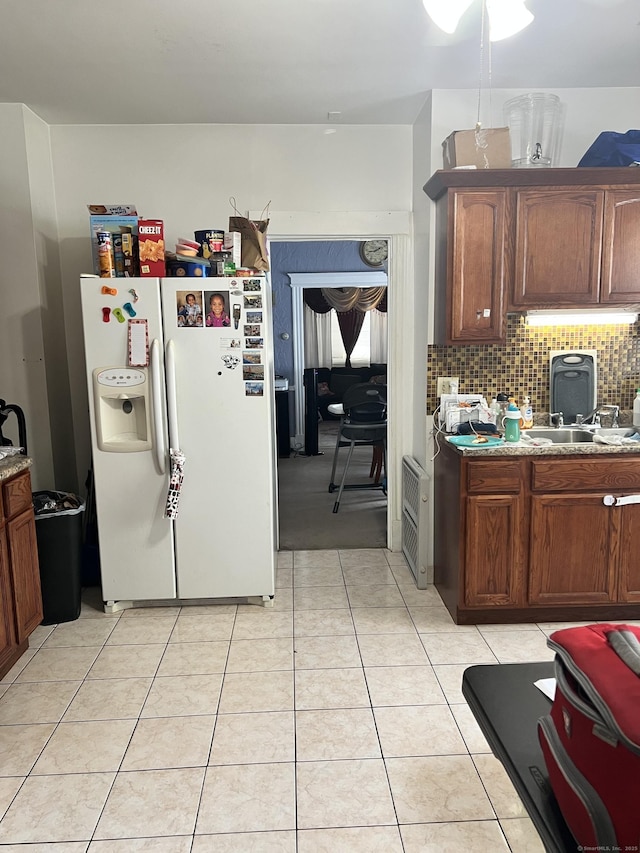70 Burnham St, Hartford, CT 06112 - kitchen with white fridge with ice dispenser, tasteful backsplash, light tile patterned floors, and heating unit