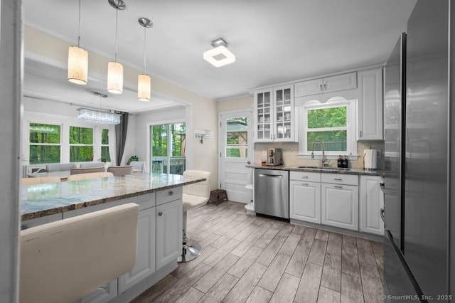 1996 Straits Tpke, Middlebury, CT 06762 - kitchen with stainless steel appliances, glass insert cabinets, light wood-type flooring, hanging light fixtures, and dark stone countertops