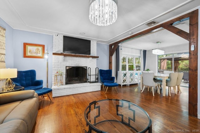 1996 Straits Tpke, Middlebury, CT 06762 - living room featuring wood finished floors, a brick fireplace, and a chandelier